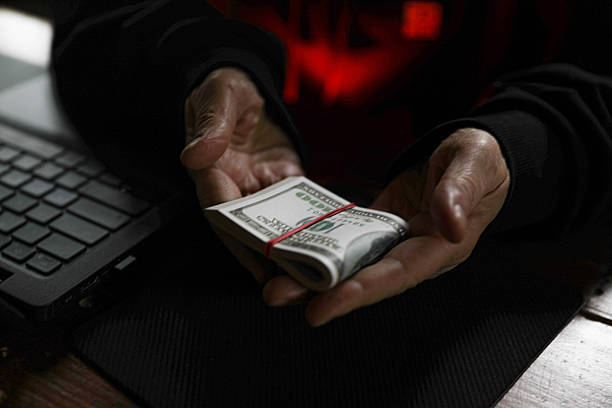 Anonymous Figure Handling Money Under Red Light