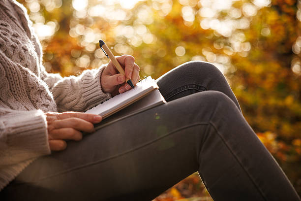 istock Woman writing diary outdoors 2252056288