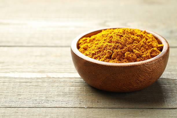 istock Turmeric powder in bowl on wooden table, closeup. Space for text 2252057901