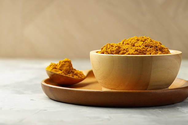 istock Turmeric powder in bowl and spoon on light grey table, closeup 2252057977