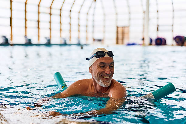istock Senior man smiling doing aqua aerobics in swimming pool 2252057985