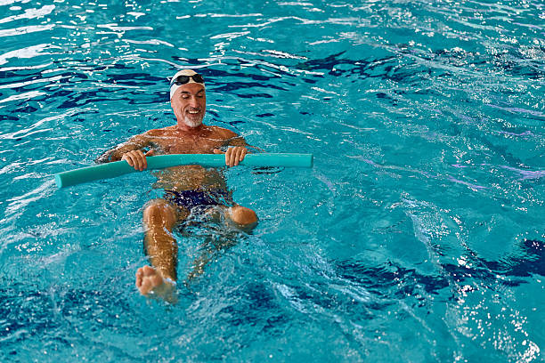 Before swimming. Group of people doing leaning and stretching before swimming