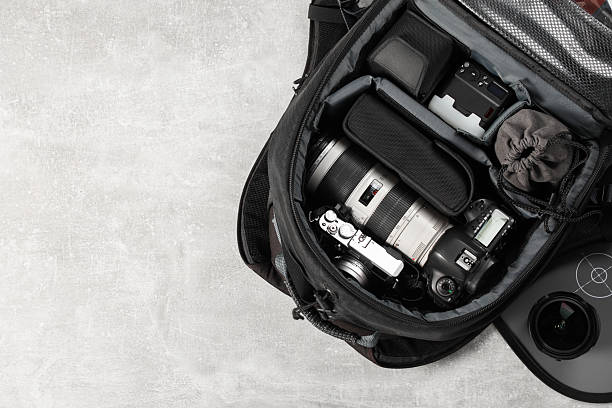 istock Professional photographer's equipment in backpack on light table, top view. Space for text 2252058381