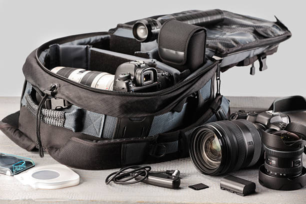 istock Professional photographer's equipment and backpack on light wooden table 2252058391