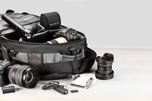istock Professional photographer's equipment and backpack on light wooden table 2252058436