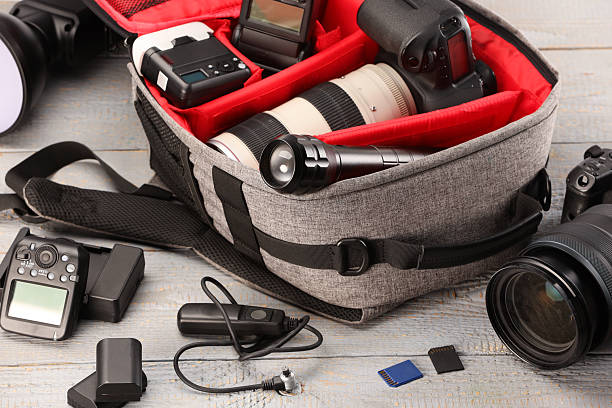 istock Professional photographer's equipment and backpack on light wooden table 2252058437