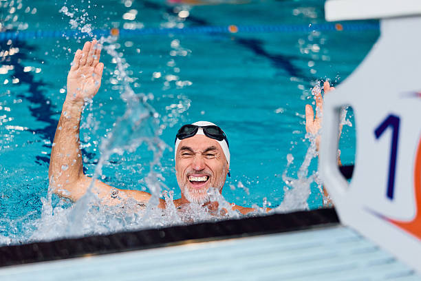 istock Senior man celebrating swimming competition victory in pool 2252058616