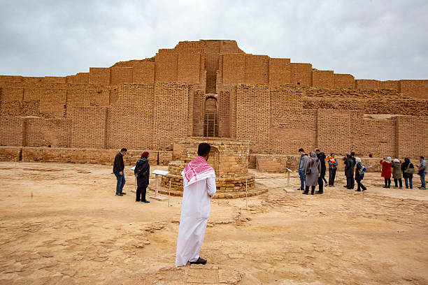 Visitors walking around the ruins of Chogha Zanbil, an ancient ziggurat in southwestern Iran. The image emphasizes cultural tourism, archaeology, and historic preservation.