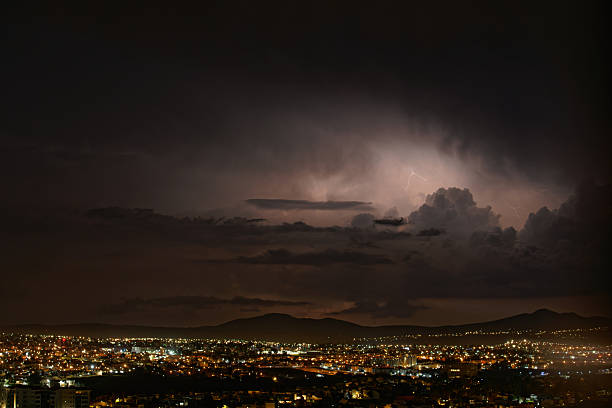Puebla city and Popocatepetl volcanic landscape during rain with bright lightning