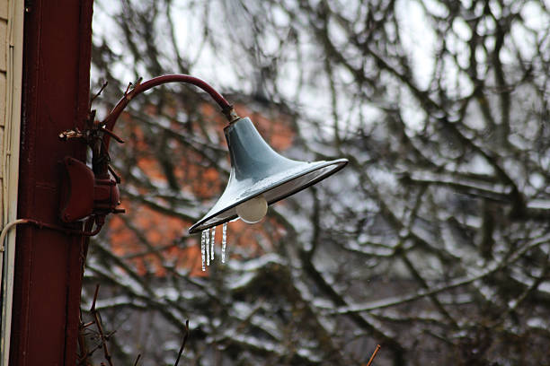 A lamp out in the winter with ice spikes on it