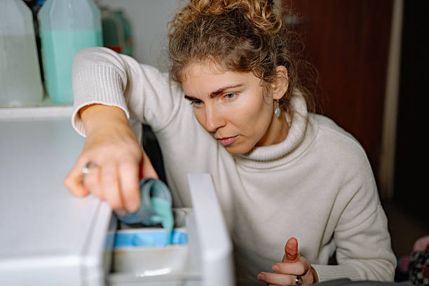 istock Woman doing laundry at home while pouring detergent into washing machine during morning hours 2252071886