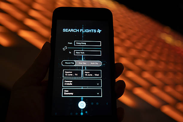 istock Using a mobile phone to book a flight under the background of city lighting 2252072239