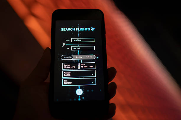 istock Using a mobile phone to book a flight under the background of city lighting 2252072244