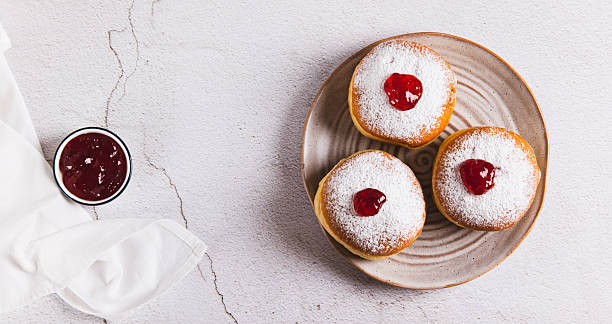 istock Delicious jam filled donuts with powdered sugar on a plate on the table top view web banner 2252072362
