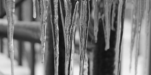 Several icicles hanging from a surface. Close-up nature photography. Winter weather scene or landscape banner. Beauty in nature.