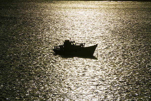 Silhouette of a boat on the sea. Water texture, dark, black.