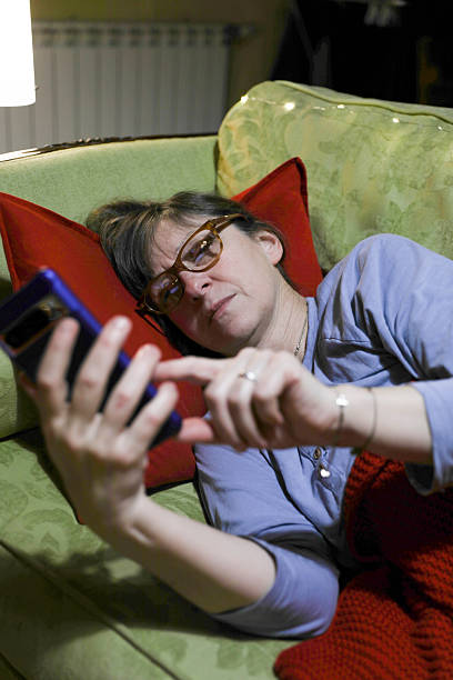 istock Tired Woman Lying Down And Checking Phone At Home 2252078568