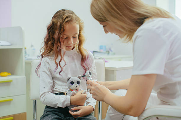 istock Girl holding toy while doctor checking ear 2252078626