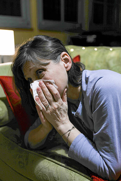istock Ill Woman Lying On Couch With Tissue In Hands 2252078681
