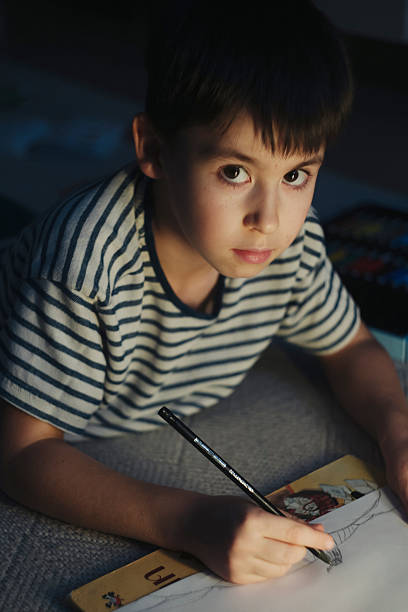 istock Caucasian child intensely working on detailed sketching project 2252079050