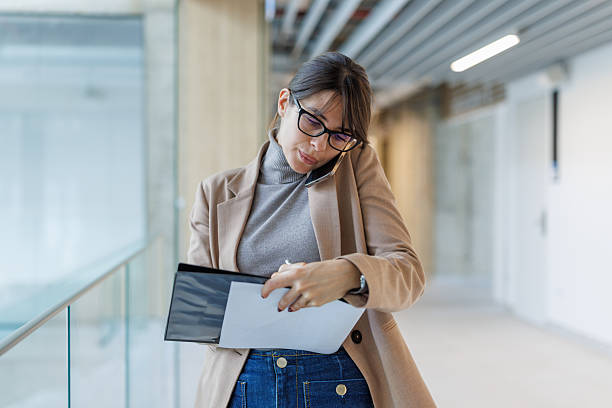 istock Businesswoman multitasking, talking on phone and writing notes in office 2252080865