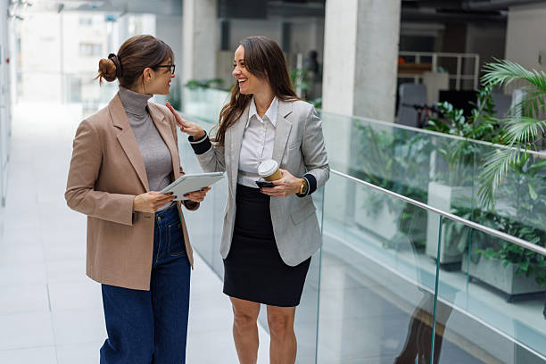 istock Businesswomen talking and collaborating in modern office hallway 2252080905