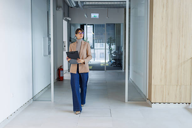 istock Businesswoman walking confident in modern office hallway 2252080925