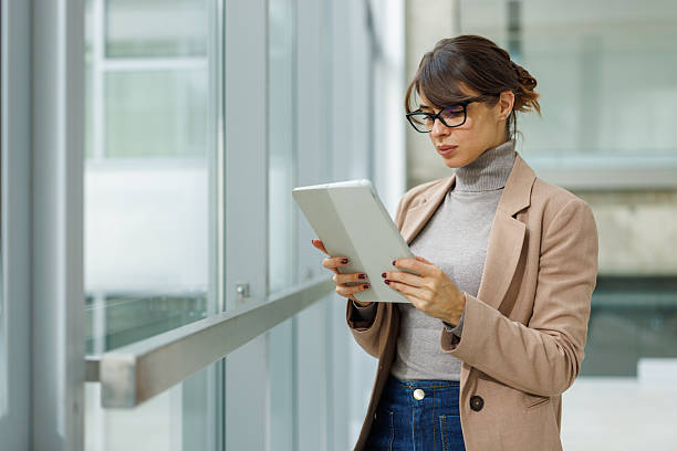 istock Businesswoman using digital tablet standing in modern office 2252080951