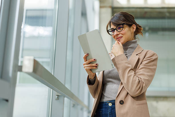 istock Businesswoman smiling reading digital tablet in modern office 2252080965