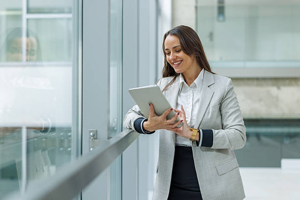 istock Businesswoman smiling while using digital tablet in modern office 2252080981