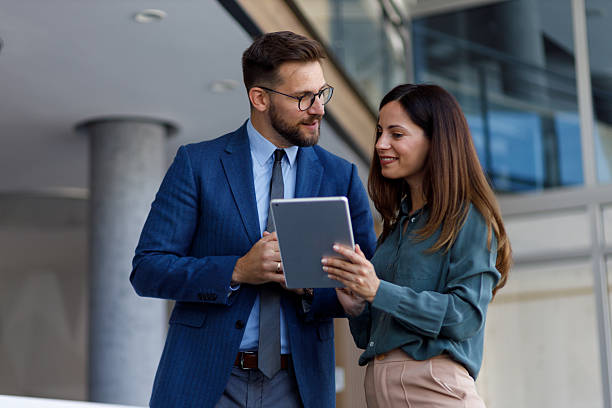 istock Business professionals discussing work using digital tablet, collaborating on a project in a modern office environment 2252081558