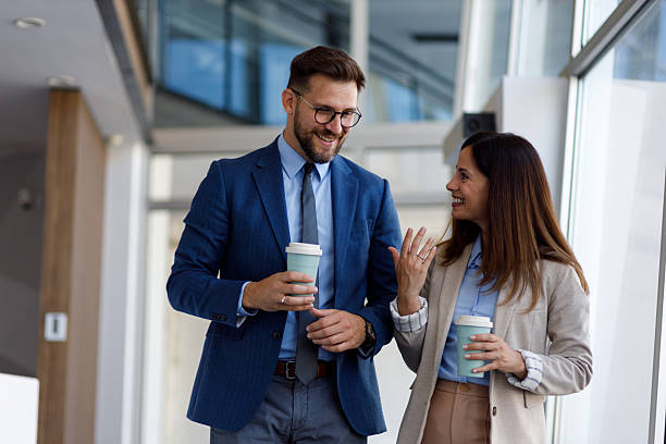 istock Two coworkers strolling down the office corridor, taking a coffee break and engaging in a lively chat 2252082750