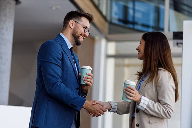 istock Business partners shaking hands at office building while having coffee during a formal meeting 2252082797