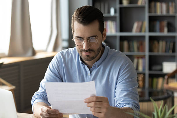 istock Young businessman reading paper document received by mail in office 2252082963