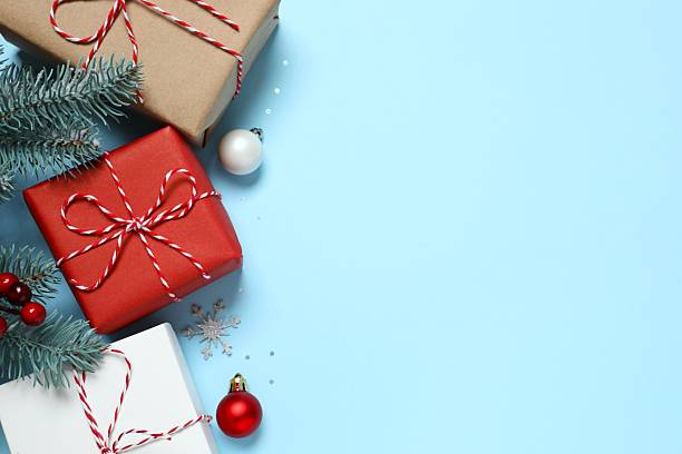 istock Beautiful gift boxes tied with bows and Christmas decorations on color background 2252083324