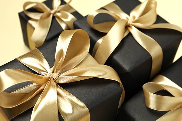 istock Beautiful gift boxes tied with golden bows on color background 2252084232