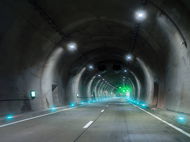 istock Modern illuminated road tunnel with curve green light and ventilation system 2252085826