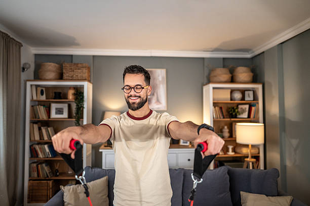 istock Young man exercising at home using resistance bands 2252086623