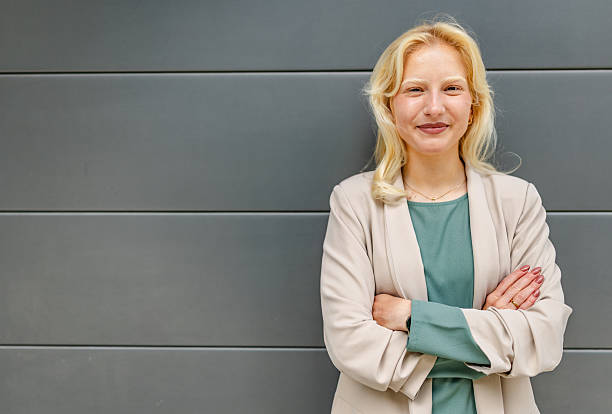 istock Young woman with albinism smiles outdoors during a sunny day while dressed in professional attire 2252095649