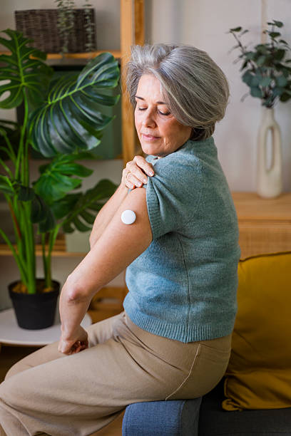 istock Mature adult woman managing diabetes using glucose sensor 2252096095