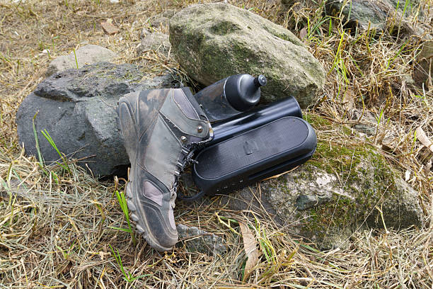 istock Hiking boot, water bottle, and portable speaker on rocks 2252099144