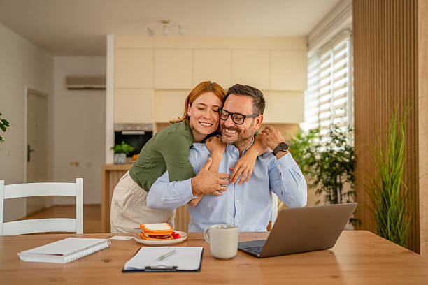 istock Happy couple embracing, working from home with laptop 2252101933