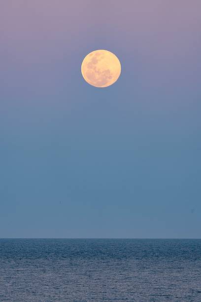 istock A December supermoon rises above the ocean as the sun sets 2252103789