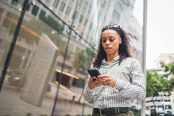 istock Professional woman using smartphone outside modern office in urban environment 2252104841