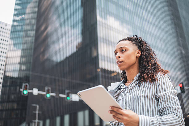 istock Professional woman using a tablet in a bustling urban environment 2252104848