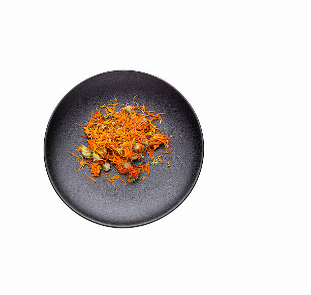 Calendula officinalis - Organic calendula petals in a dark bowl