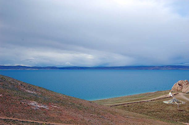 istock Serene Lake Amidst Rugged Terrain Under Cloudy Sky 2252112964