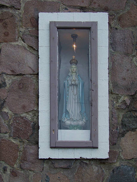 A vintage ceramic figurine of Mother Mary rests in a glass-protected niche on an exterior wall of the Saba Chapel. 2009