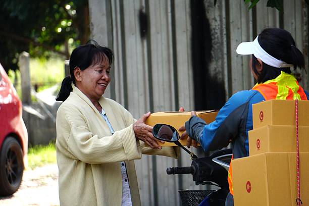 Elderly customer happily receiving a parcel box from the delivery man.