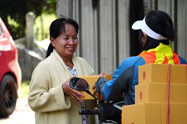Delivery man and elderly customer chatting friendly during delivery.